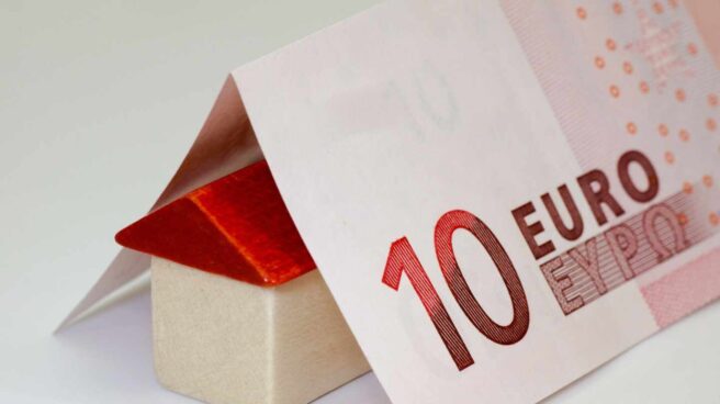 El euríbor ha subido al -0,237% Un billete doblado en forma de tejado sobre una casita de juguete.