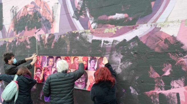 Varios vecinos colocan rostros de mujeres sobre el mural vandalizado de Ciudad Lineal.