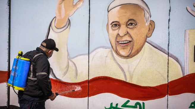 Un obrero fumiga la imagen de un cartel que anuncia la visita del Papa a Irak