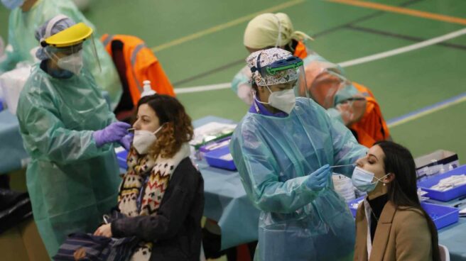Sanidad notifica 26.136 nuevos contagios y la incidencia supera los 412 casos Dos pacientes se hacen una prueba de coronavirus en un centro deportivo.