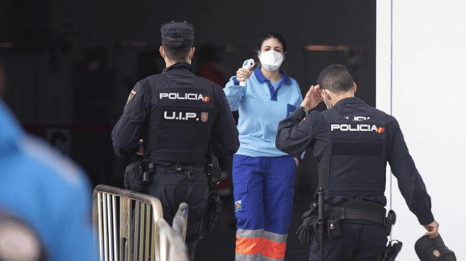 Policías nacionales acceden al centro de vacunación en Sevilla.