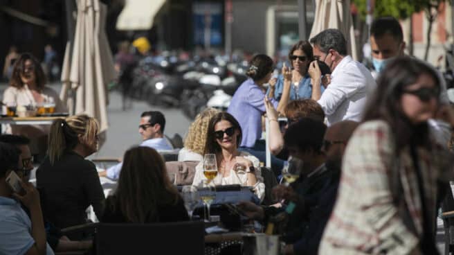 Personas en la terraza de un bar en Sevilla, en Andalucía.