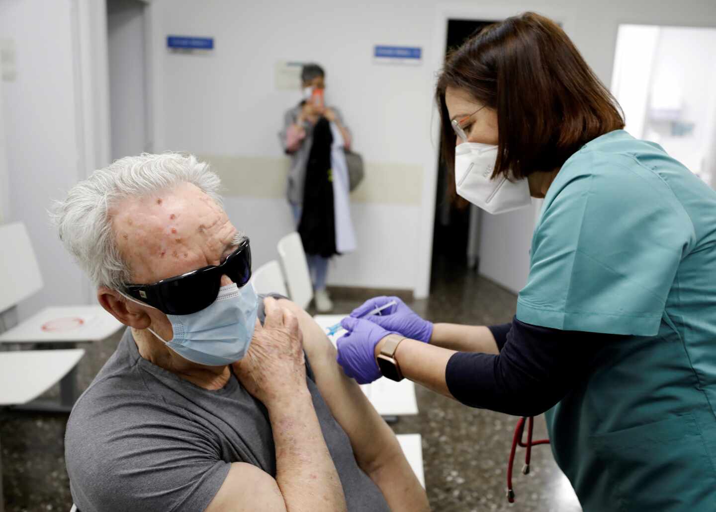 Una sanitaria vacuna a una persona mayor en un ambulatorio de Valencia.