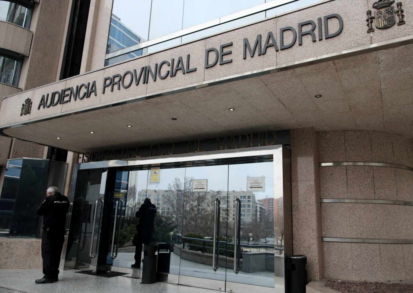 Un agente de la Policía Nacional junto a la puerta principal de la Audiencia Provincial de Madrid