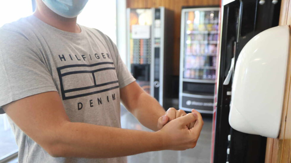 Un colegial del Colegio Mayor Aquinas se echa gel desinfectante en las manos en un dispensador colocado en las instalaciones del colegio.