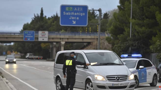 Primer día de confinamiento perimetral en Huesca (Aragón) Un agente de la Policía de Huesca realiza controles de entradas y salidas a la ciudad, en una imagen de archivo.