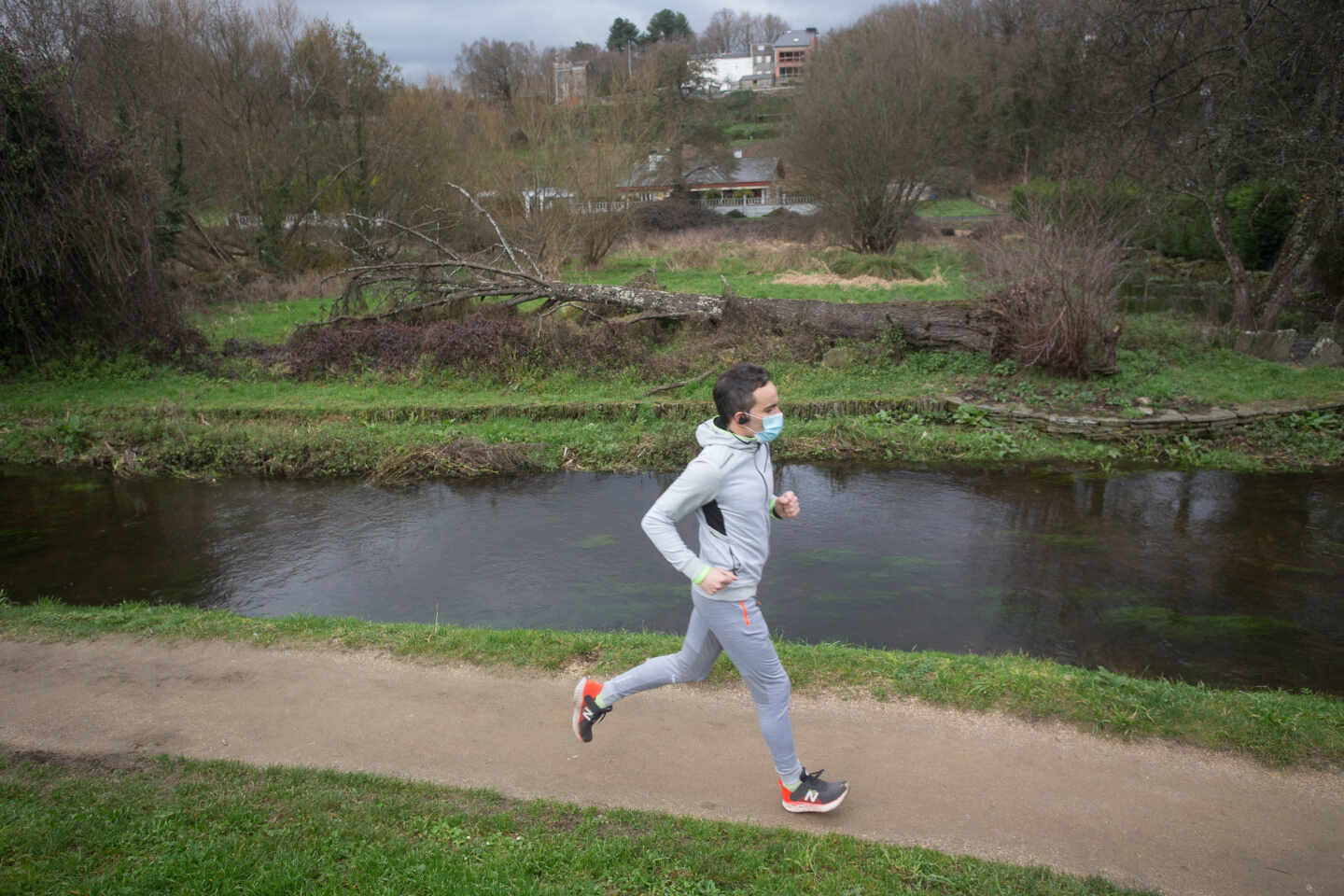 Un hombre corre frente al río Rato, antes del temporal Justine, en Lugo