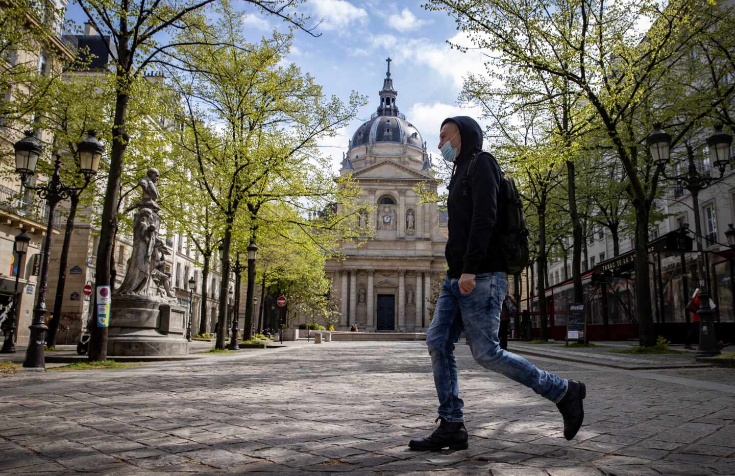 Un hombre camina delante de la Universidad de la Sorbona en París