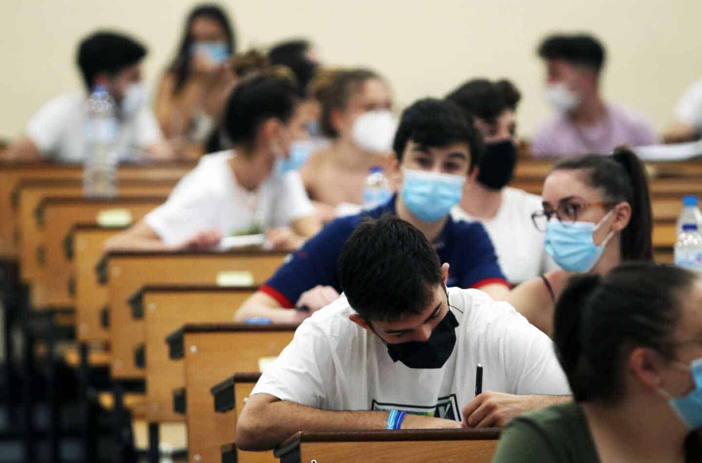 Un grupo de alumnos rellena un examen en un aula.