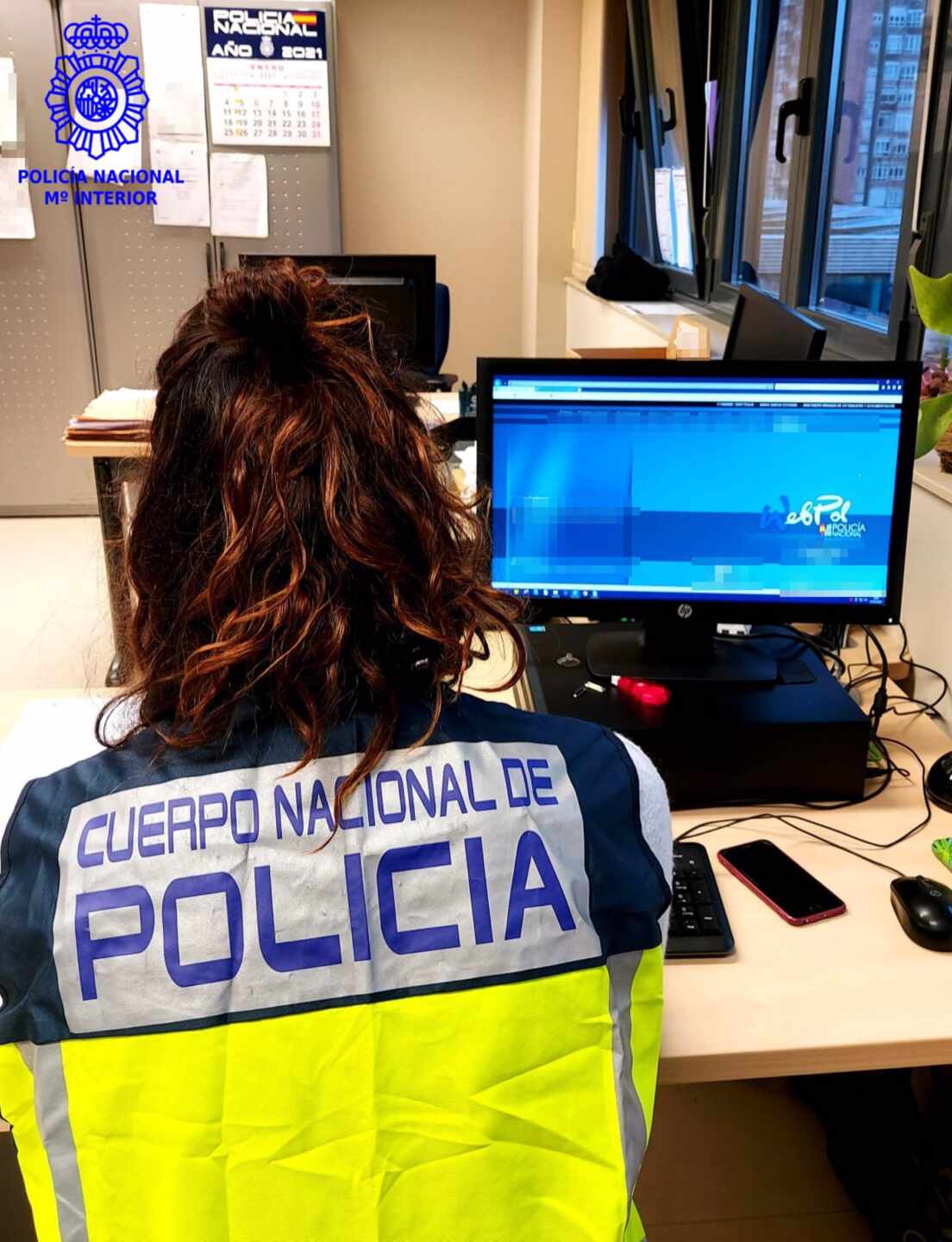 Agente de la Policía Nacional ante un ordenador