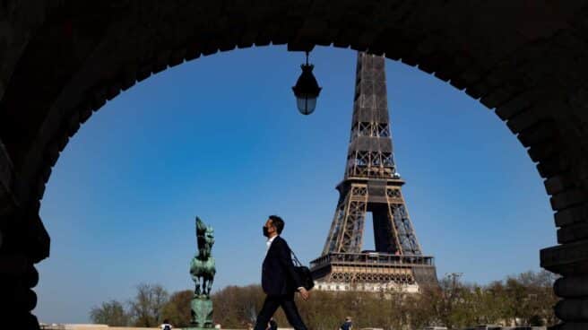 Un hombre camina en las proximidades de la Torre Eiffel.