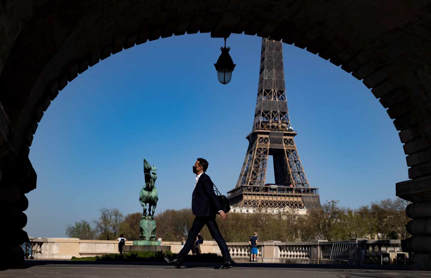 Un hombre camina en las proximidades de la Torre Eiffel.