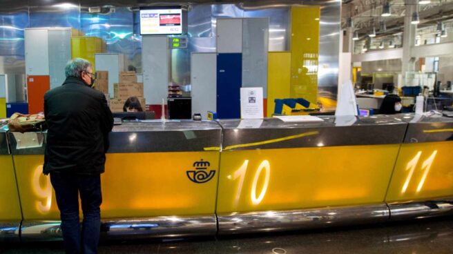 Un cliente es atendido en la oficina de Correos de Cibeles, en Madrid.