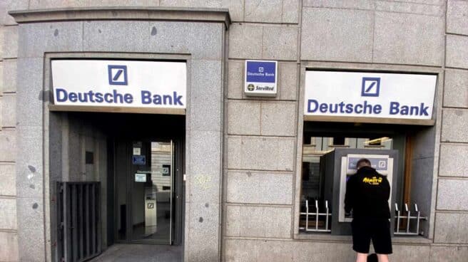 Deutsche Bank ofrece hasta 480 euros si se domicilia una nómina superior a los 1.500 euros. Un hombre retira dinero de un cajero Deutsche Bank.
