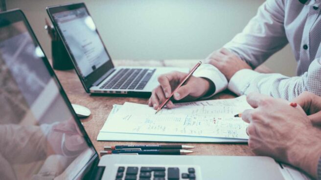 La campaña de la renta comienza este miércoles: todas las claves Imagen de mesa de trabajo con ordenadores y papeles con datos financieros