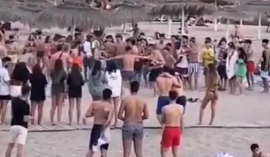 Varios jóvenes participan en una pelea con guantes de boxeo en una playa de Adeje, Tenerife.