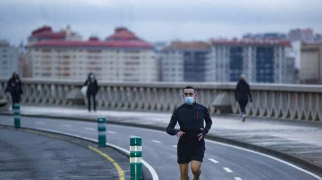Una persona corre en solitario y con mascarilla un día en Galicia.