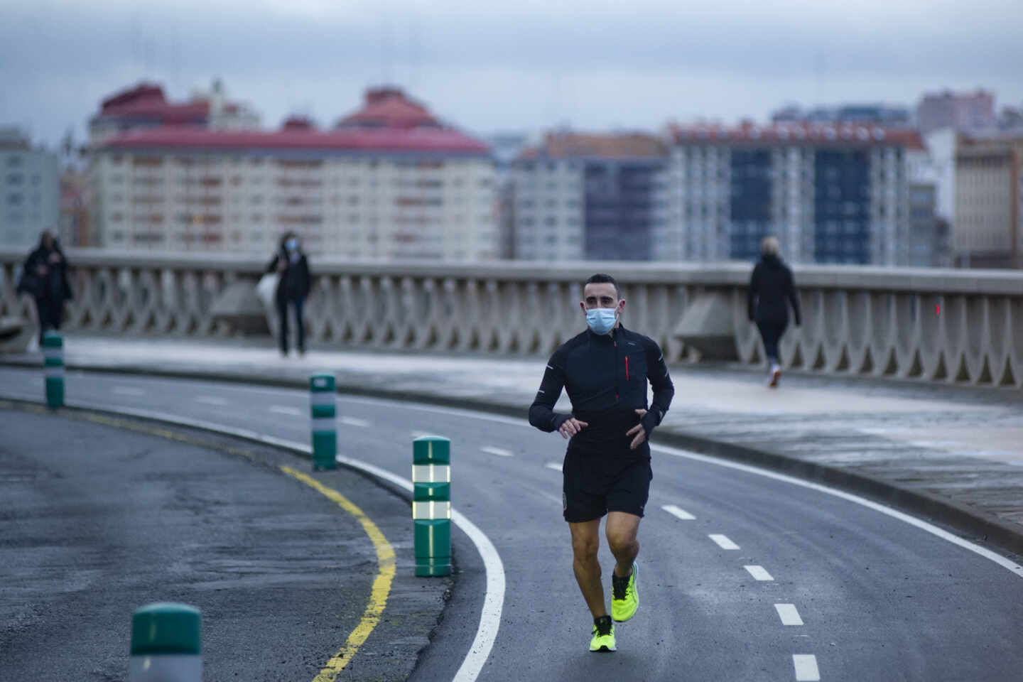 Una persona corre en solitario y con mascarilla un día en Galicia.