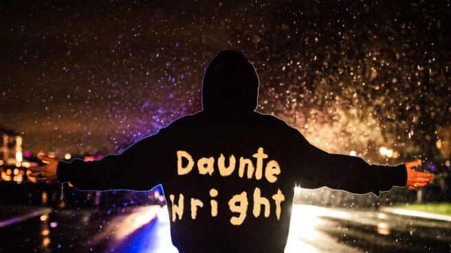 Un manifestante con el hombre de Daunte Wright en su ropa se planta ante la policía