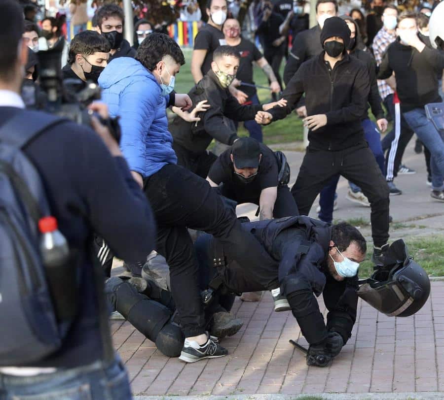 Radicales patean a un policía en el suelo durante el mitin de Vox en Vallecas.