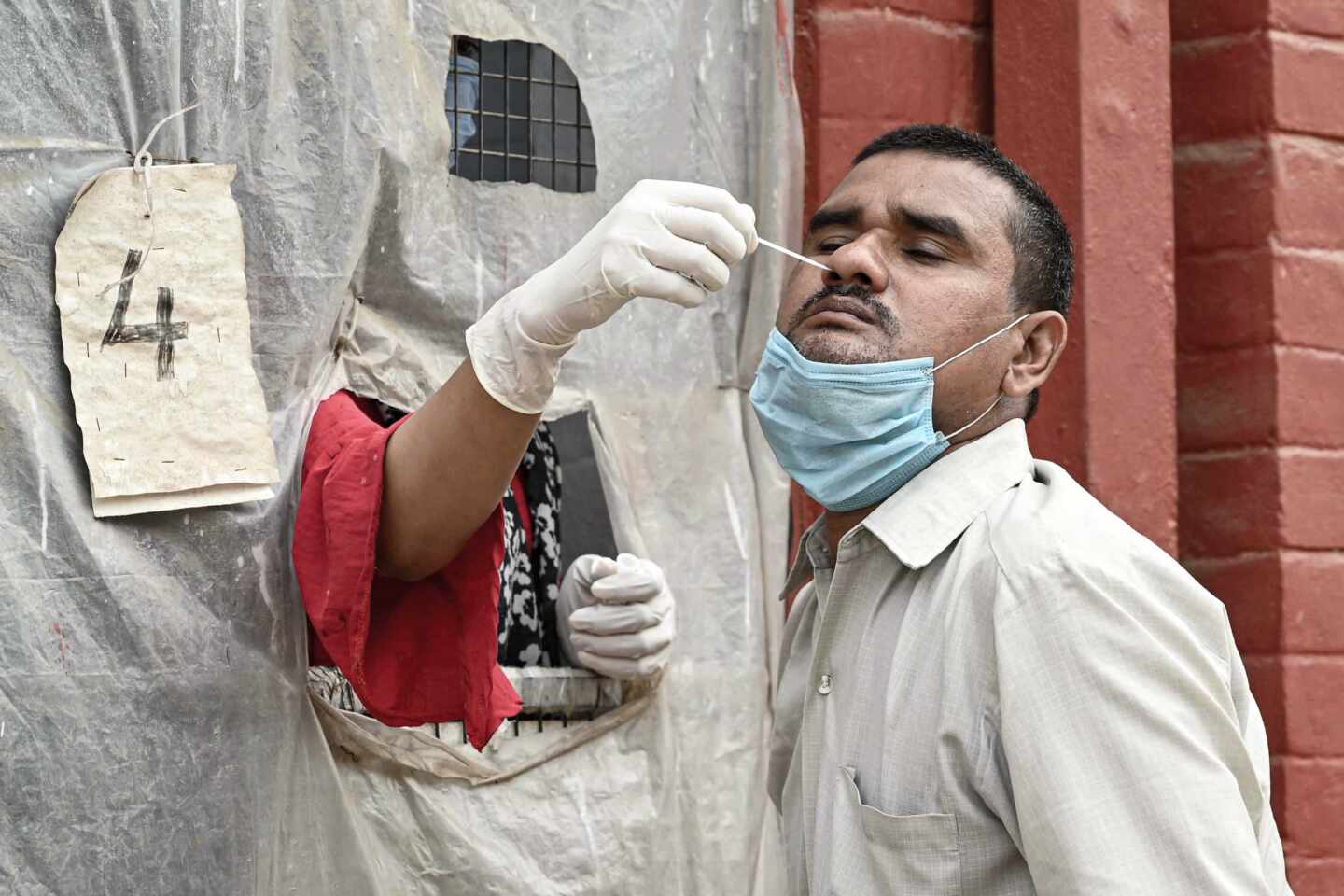 Un sanitario realiza una prueba PCR de detección de coronavirus coronavirus a un individuo en Prayagraj (India).