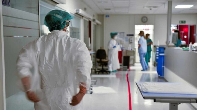 Un sanitario se coloca un traje de protección.