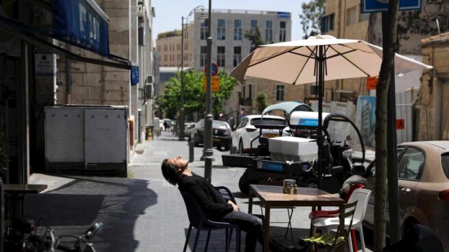 Un hombre sentado sin mascarilla en una terraza al aire libre en Jerusalén, días después de que el país eliminara el uso obligatorio de Mascarilla.