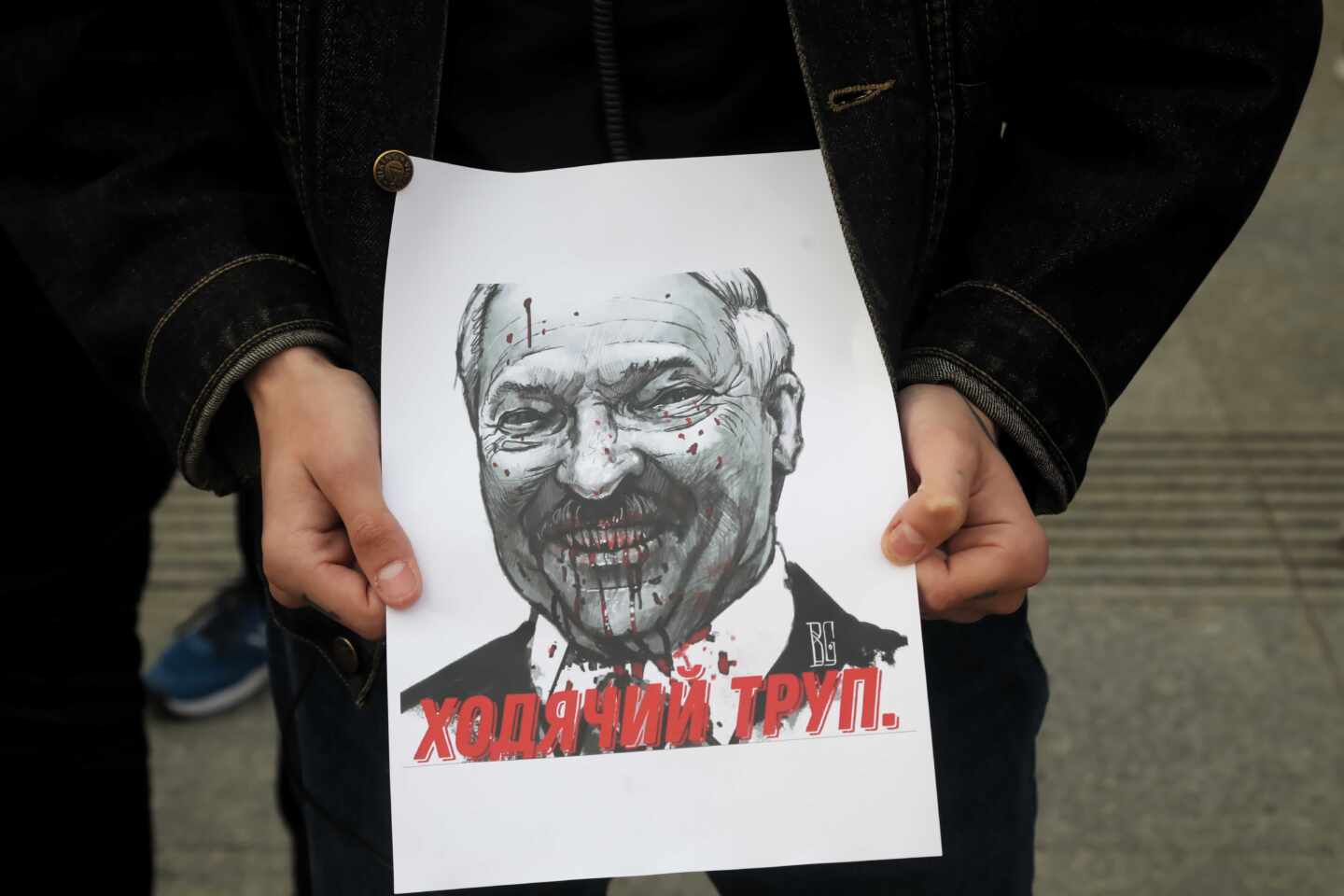 Un manifestante sostiene un cartel con la imagen de Aleksander Lukashenko, el dictador bielorruso