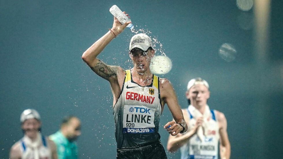 El atleta alemán Christopher Linke se echa una botella de agua en la cabeza durante la prueba de 20 km marcha en los Mundiales de atletismo de Qatar 2019