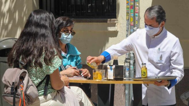 Un camarero sirve en una terraza en Madrid.