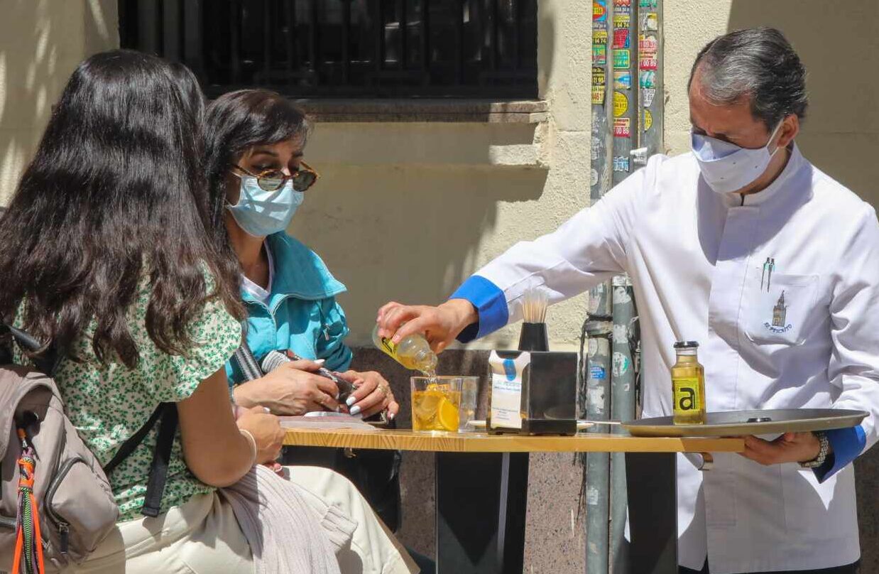 Un camarero sirve en una terraza en Madrid.