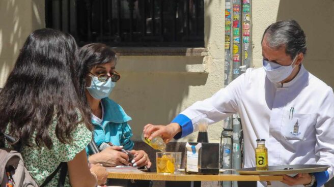 Un camarero sirve en una terraza en Madrid.