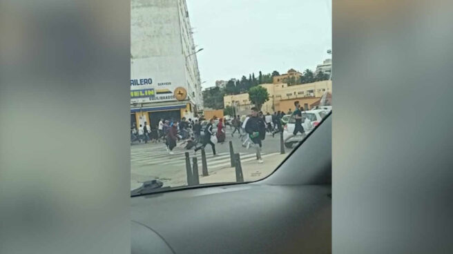 Imagen de decenas a marroquíes corriendo por las calles del puerto de Ceuta