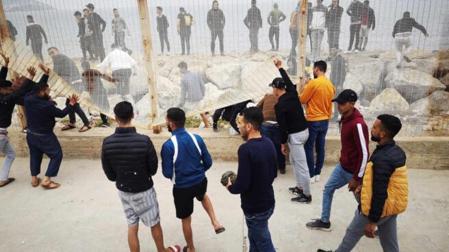 Un grupo de personas tratan de derribar la valla fronteriza en el lado marroquí