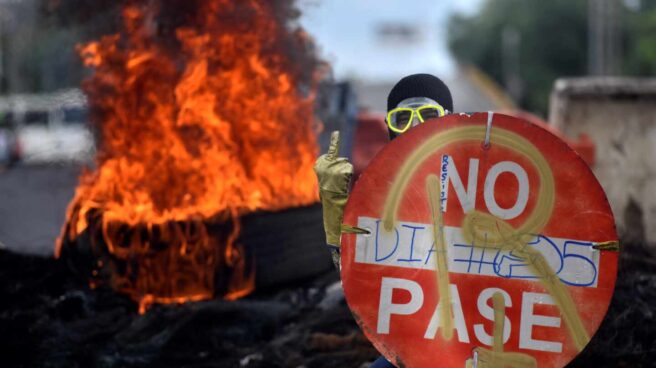 Un manifestante sostiene una señal de prohibido en una protesta contra el presidente, Iván Duque