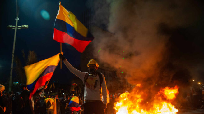 Un colombiano porta dos banderas del país en medio de las protestas en Bogotá