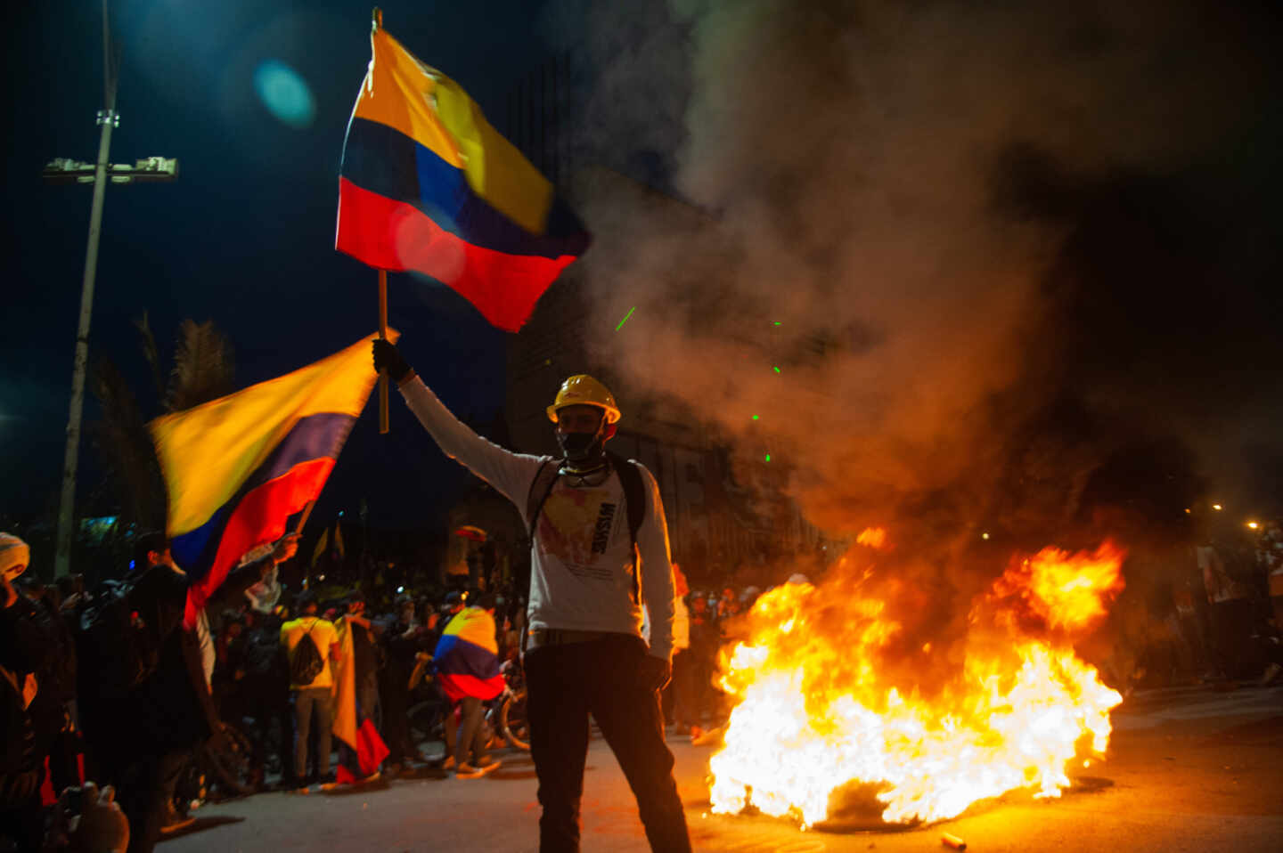 Un colombiano porta dos banderas del país en medio de las protestas en Bogotá