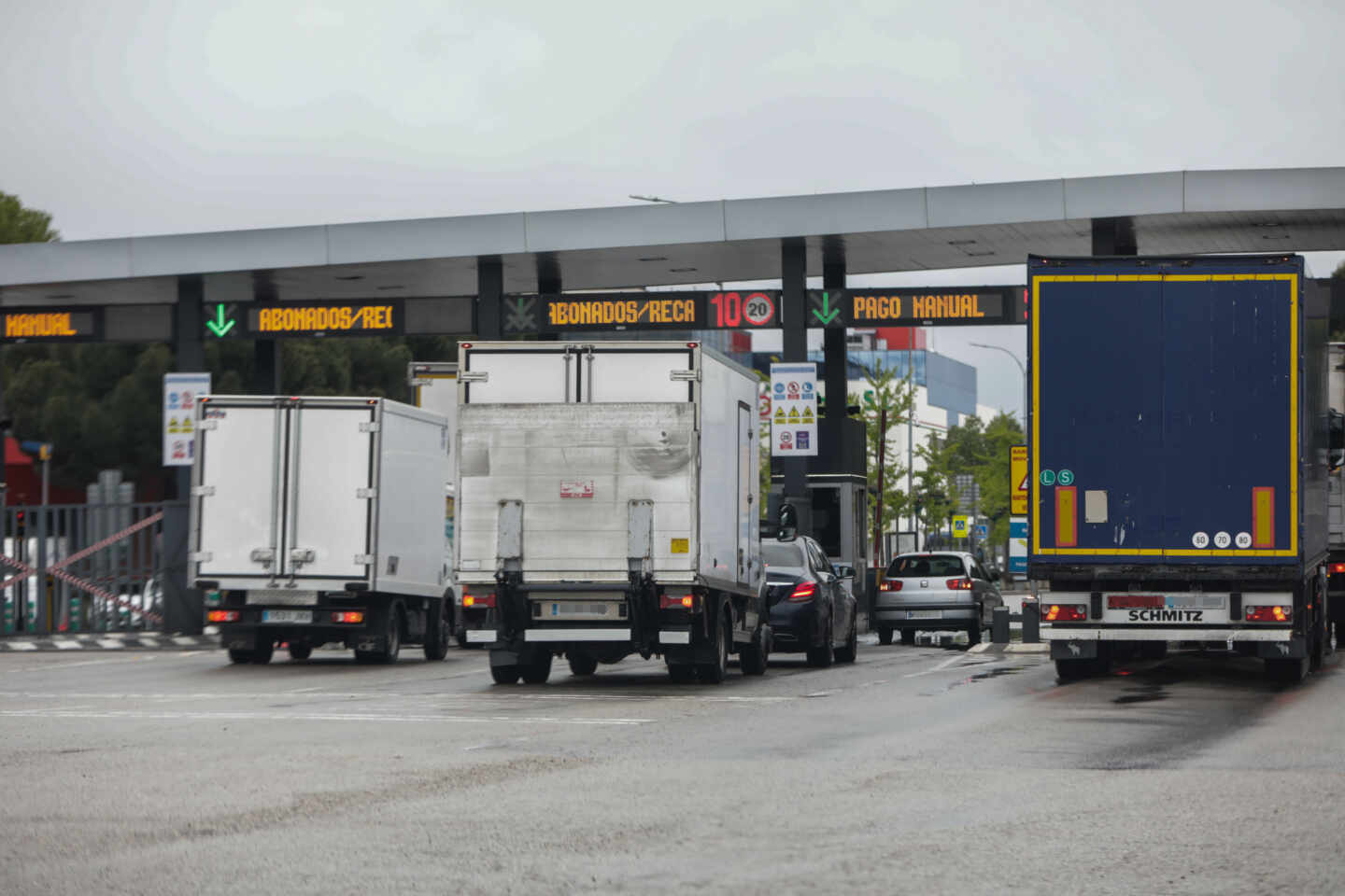 Varios camiones esperan para pasar por un acceso de peaje.