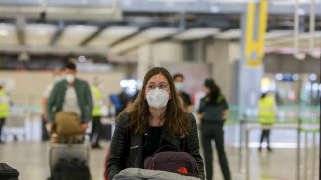 Una joven protegida con mascarilla camina por el Aeropuerto de Madrid-Barajas Adolfo Suárez.