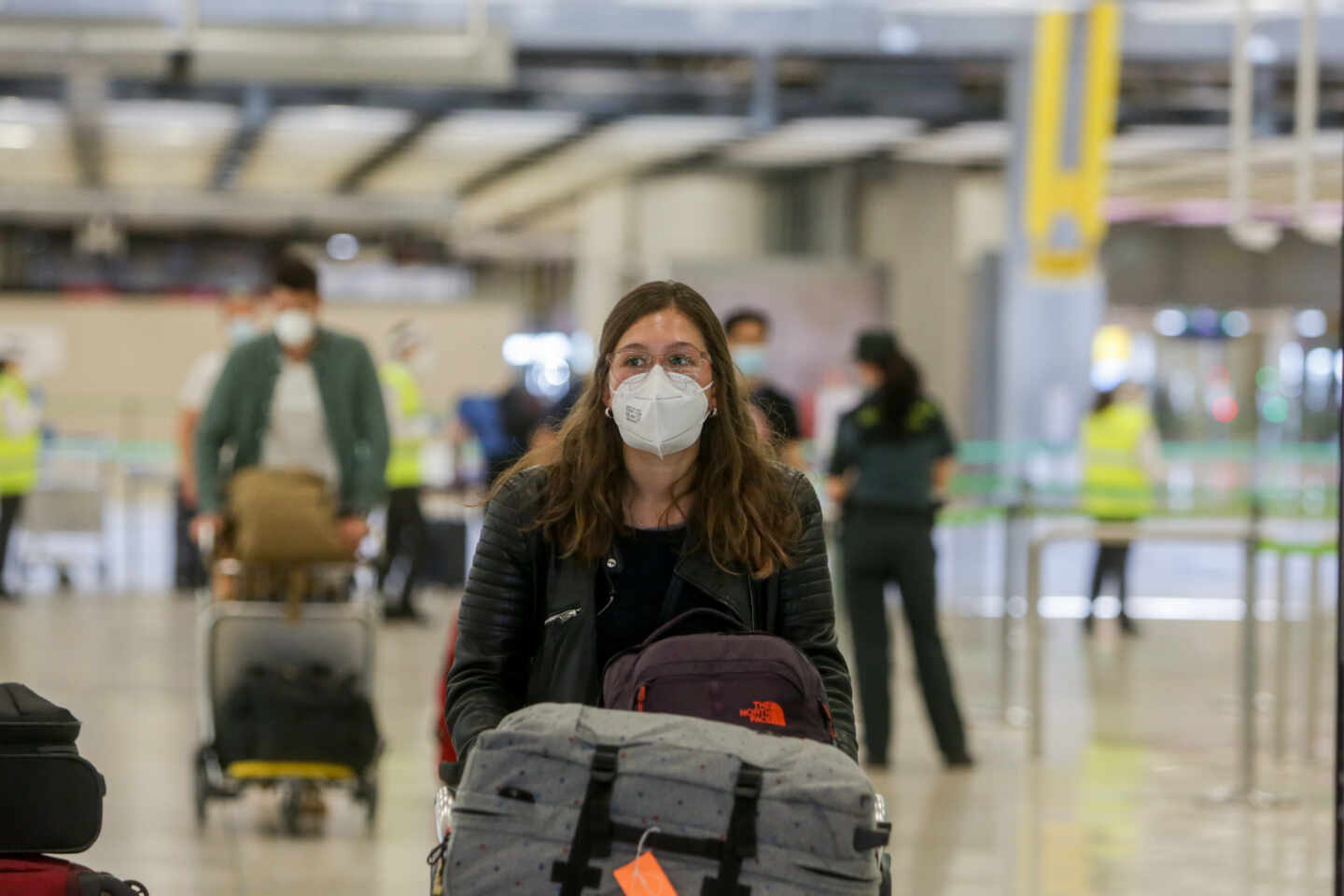 Una joven protegida con mascarilla camina por el Aeropuerto de Madrid-Barajas Adolfo Suárez.
