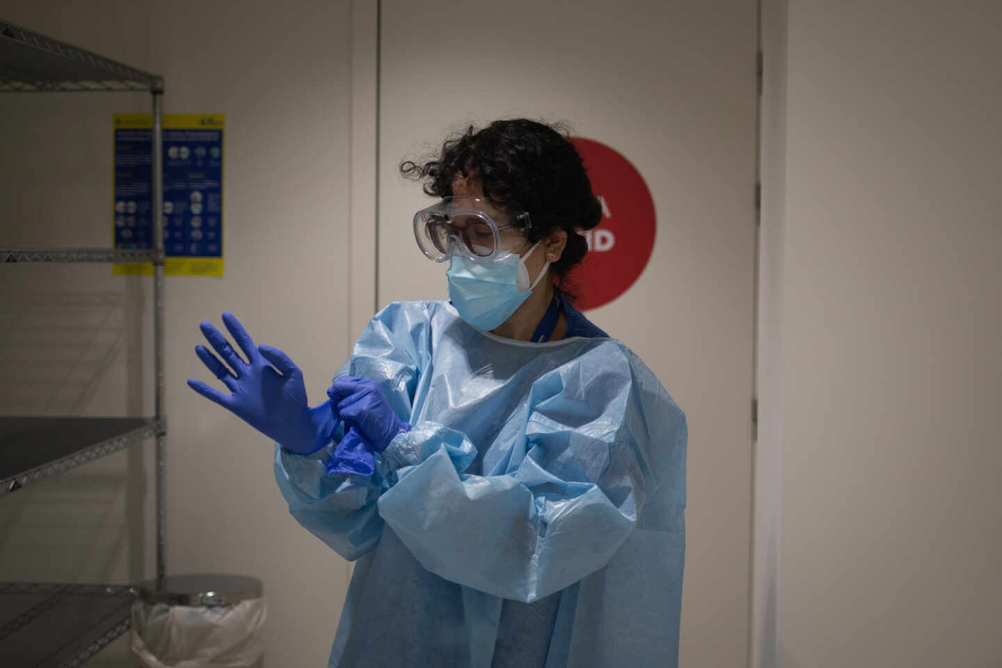 Una profesional sanitaria se viste con un Equipo de Protección Individual (EPI) en el edificio Garbí-Vall de Hebrón, en Barcelona