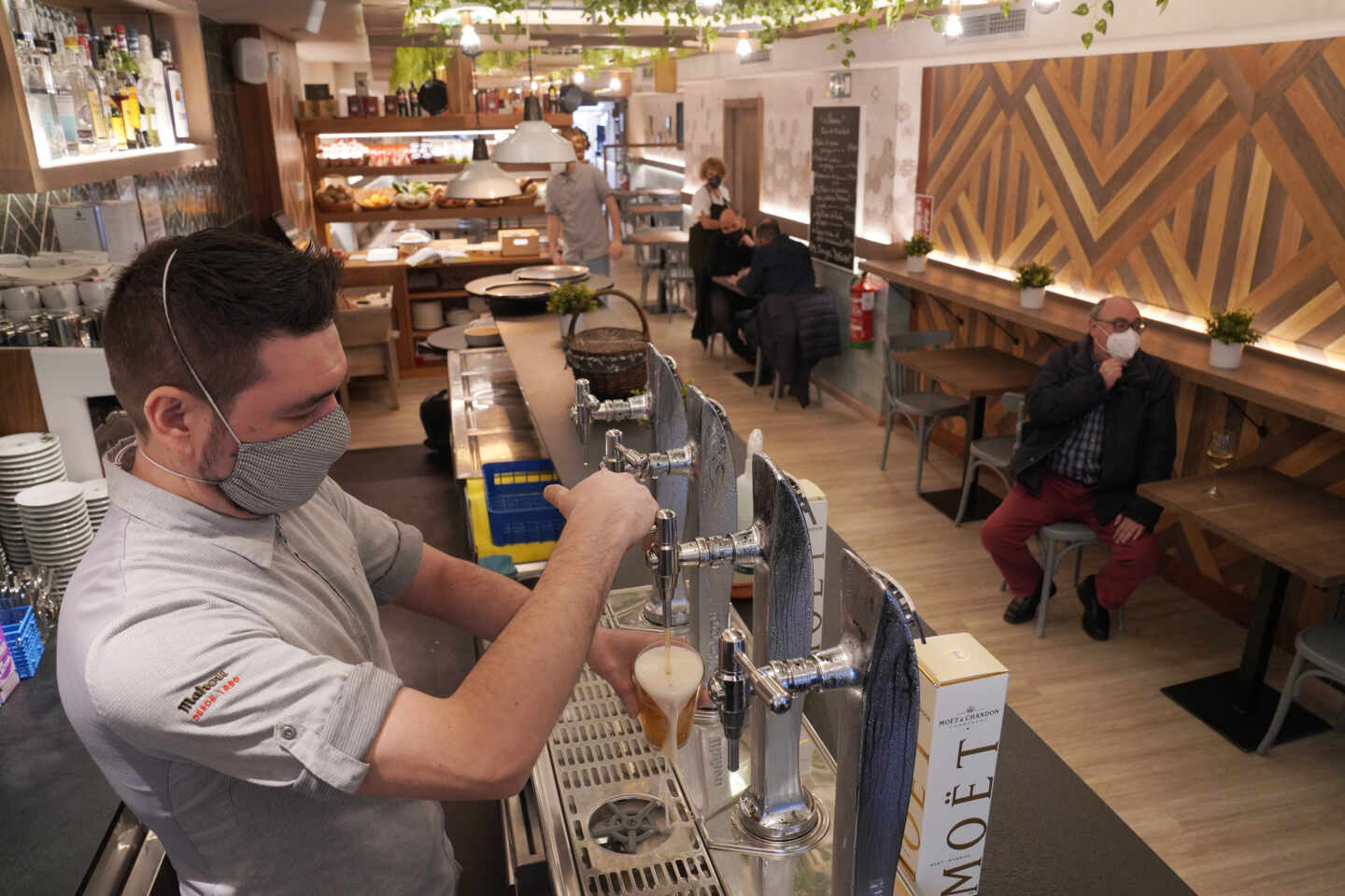 Un camarero llena un vaso de cerveza en un restaurante.