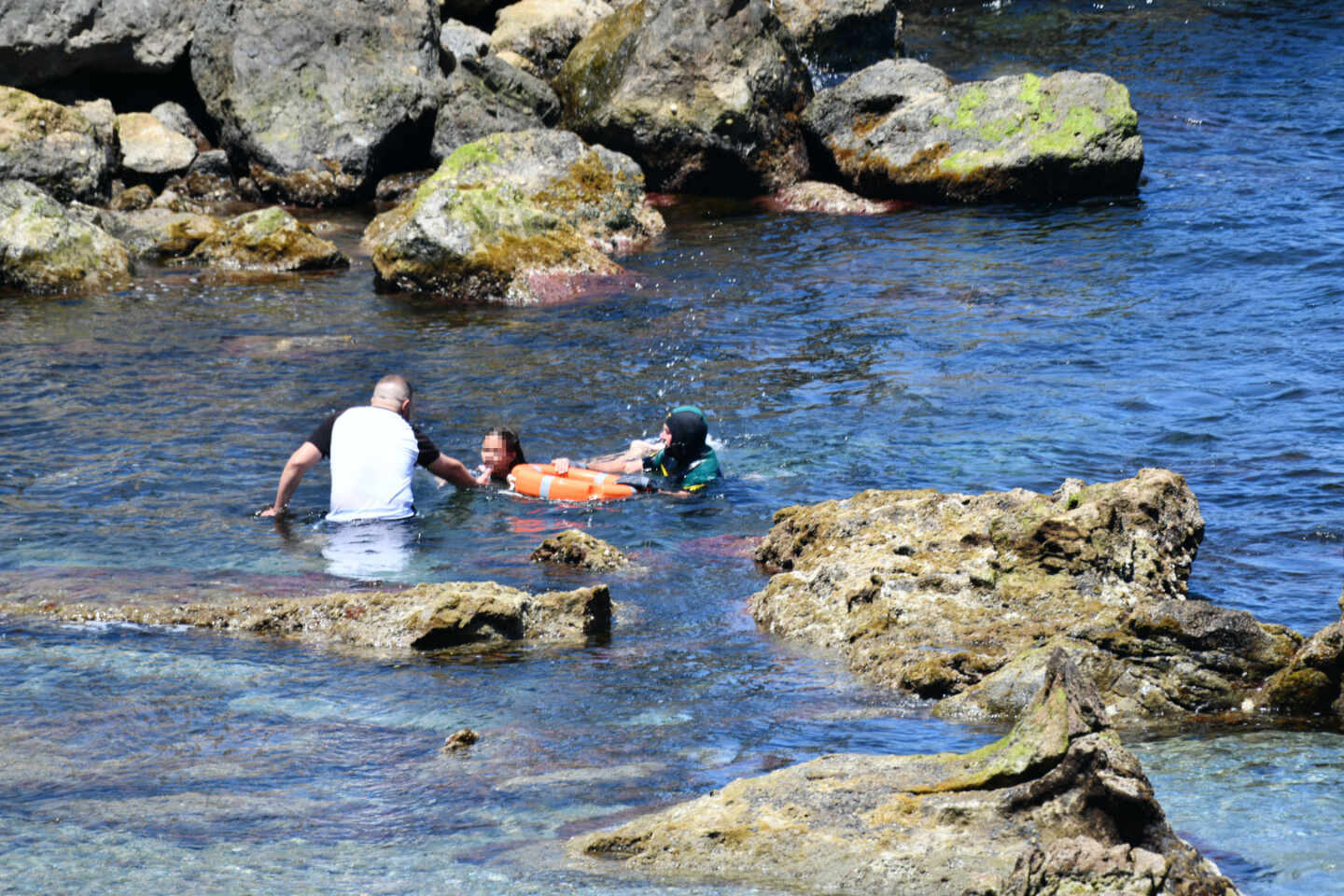 El Grupo Especial de Actividades Subacuáticas (GEAS) de la Guardia Civil traslada a varios migrantes marroquíes que han llegado a la playa del Benzú en Ceuta