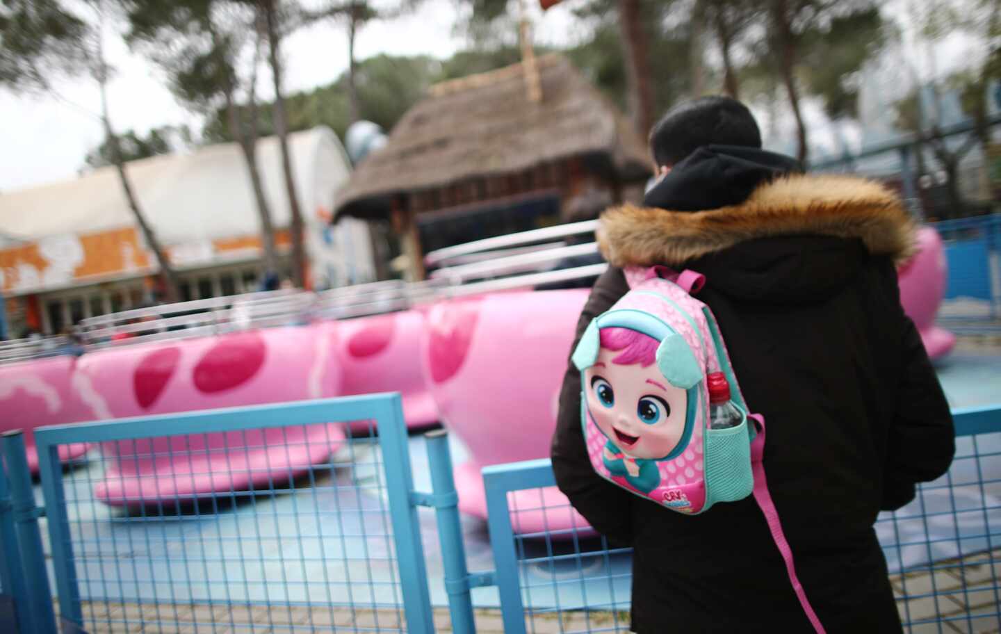 Un hombre con una mochila en un parque de atracciones en Madrid.