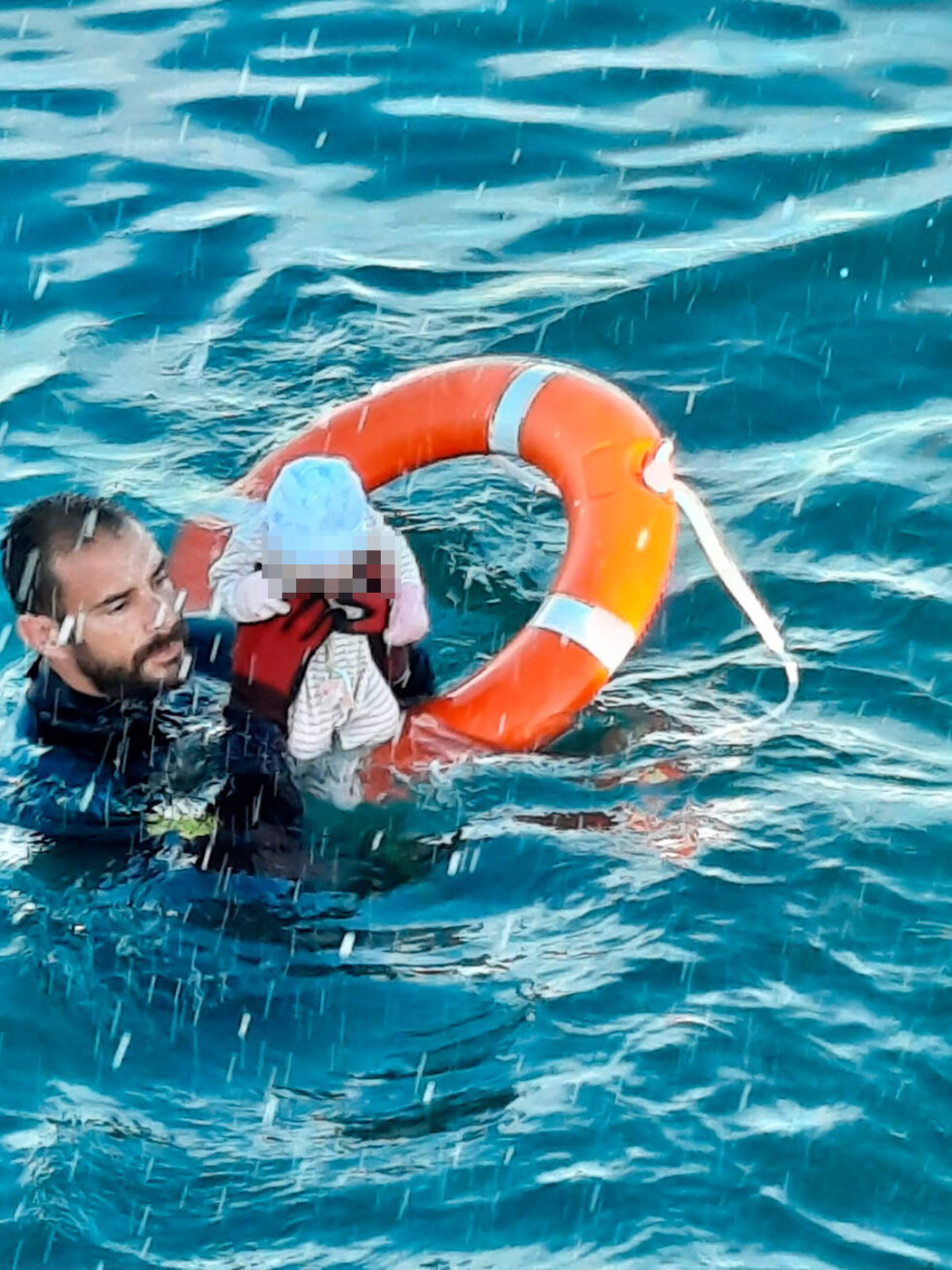 Un Guardia Civil lleva en volandas a un bebé recién nacido en la playa de Ceuta