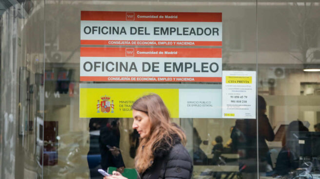 La tasa de paro cerrará este año en el 12,8%, un punto menos que en 2019, según Asempleo Una mujer pasa junto a una Oficina de Empleo de Madrid.