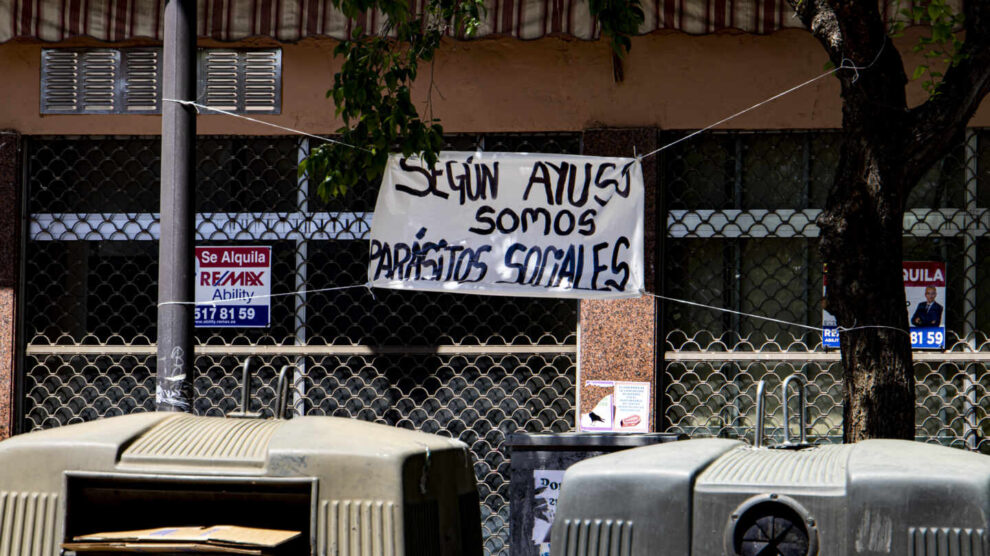 Un cartel contra Ayuso en una calle cercana a la Plaza de la Constitución