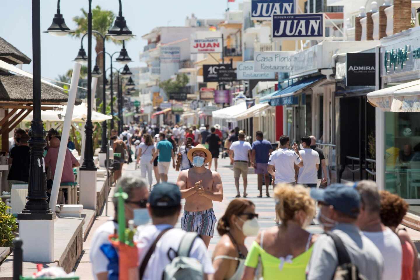 Varias personas disfrutan del buen tiempo paseando por el paseo marítimo de la playa de La Carihuela de Torremolinos