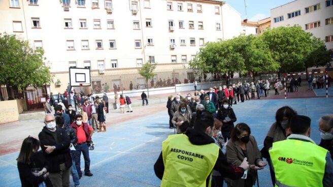 Cientos de personas hacen cola para votar en un colegio electoral de Madrid.