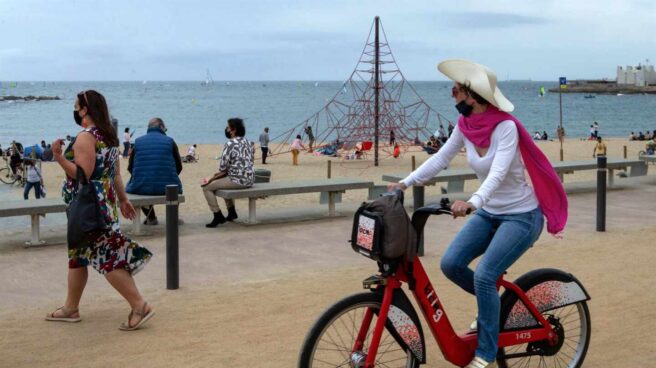 Una mujer pasea en bicicleta por la Barceloneta. Una mujer pasea en bicicleta por la Barceloneta.
